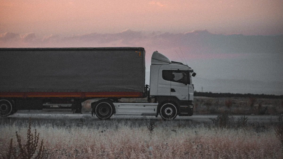 Caminhão de carga em rodovia ao entardecer, representando a pesagem rodoviária integrada ao ERP na indústria