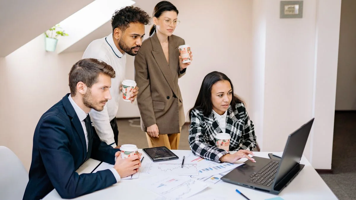 Equipe avaliando e comparando ferramentas de IA juntos no laptop
