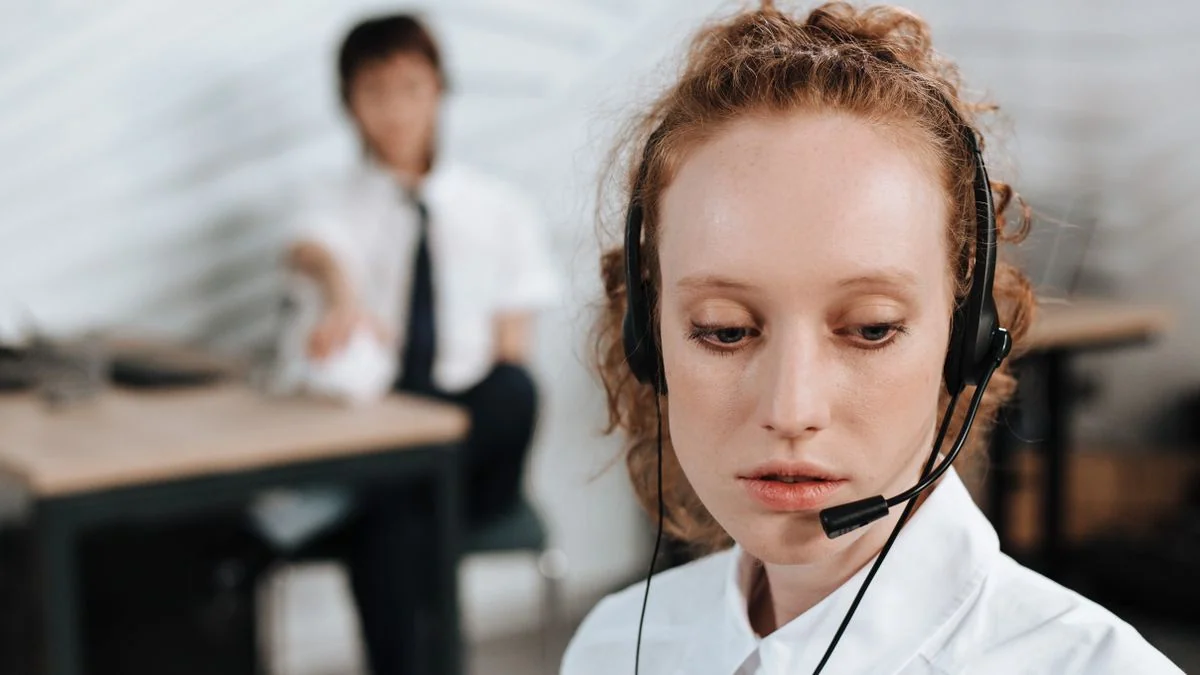 Atendente de suporte ao cliente usando headset em central de atendimento